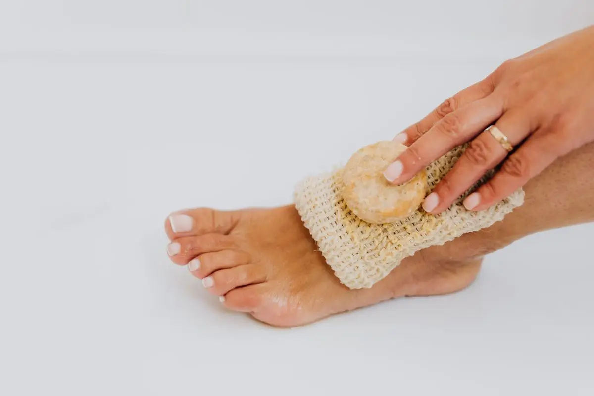 A close-up of a foot being exfoliated with a natural scrub.
