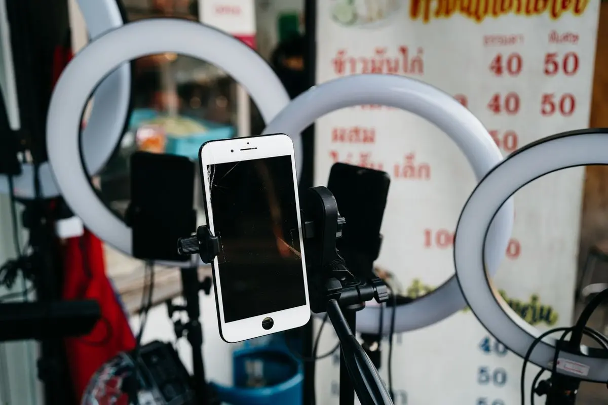 Uno smartphone montato su un treppiede circondato da luci ad anello.