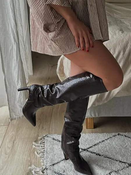 Dunkle Boots, rote Nägel.