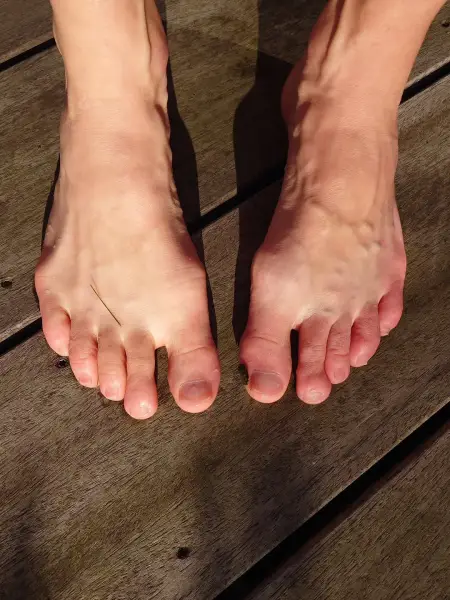 Bare toes on wood, a grass souvenir. 🌿